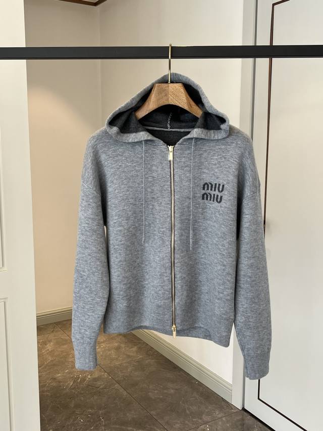 原版开发系列。 100%羊毛 。 2025新品双面针织羊毛 连帽拉链开衫 这款标志性的拉链开衫采用双面针织羊毛重新设计，并饰有Miu嵌花标志，凸显其现代休闲的一