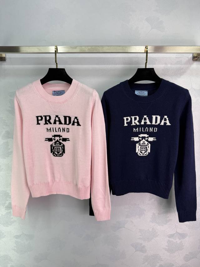 Prada普拉达针织毛衣，粉色和深蓝色两色可选，胸前Prada字母刺绣图案，圆领套头设计，长袖款式。手感细腻柔软，适合秋冬穿着。搭配裙装或裤装都很百搭。2色3码