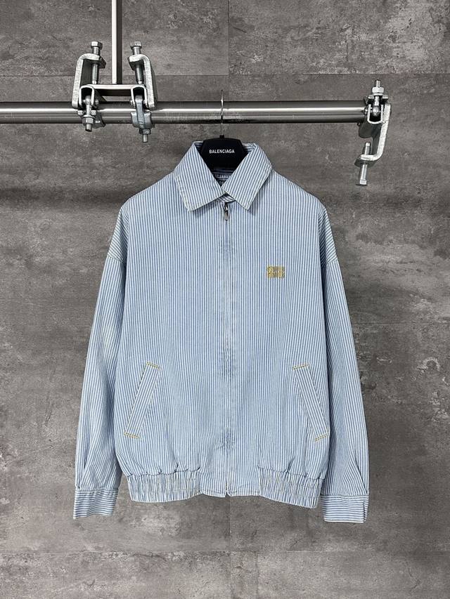 Miumiu 缪缪 25Ss 刺绣Logo条纹拉链牛仔蓝夹克外套 男女同款 定织定染高支数斜纹纺织，赋予面料硬挺的骨骼感与细腻的肌理触感。条纹结构确保抗皱性与耐