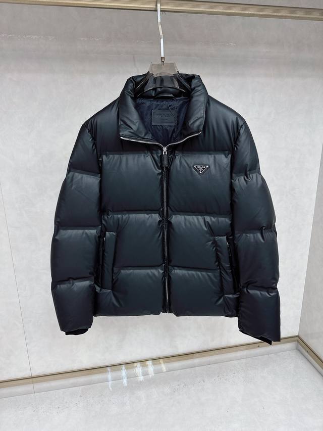 prada25秋冬款立领羽绒外套 prada这款外套采用高品质羽绒填充工艺. 经多道工序处理，确保羽绒均匀分布、充分蓬 松，保障保暖性；提升耐用度，优化穿着体