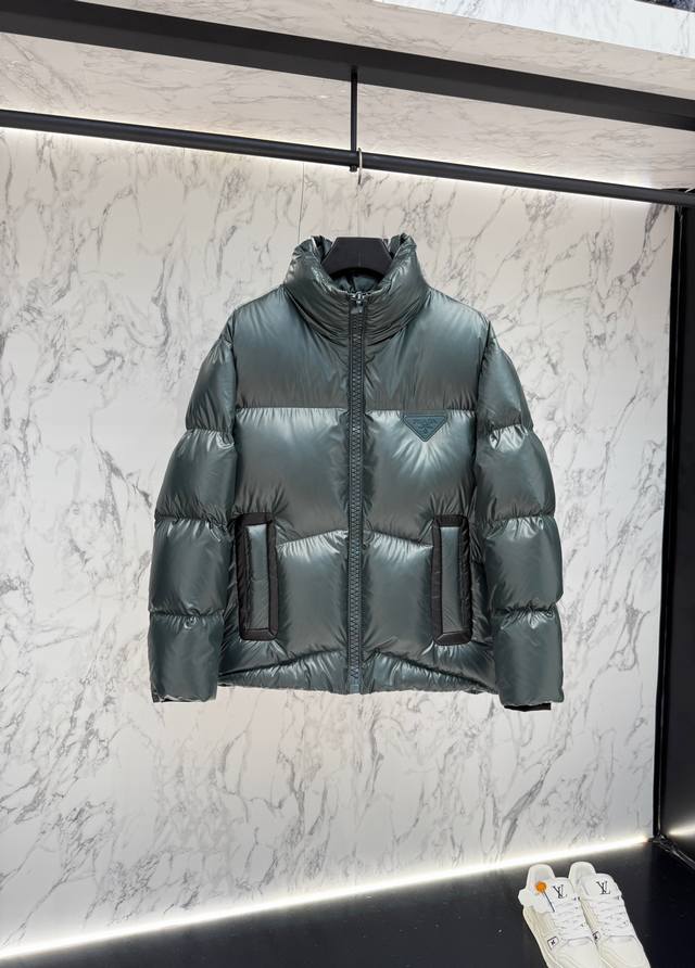 放货价 prada普拉达新款提花尼龙羽绒服金属小标羽绒服。羽绒服采用Re-Nylon再生尼龙打造，现代设计风格,和廓形相得益彰，采用95的白鸭绒给予更温暖防护标