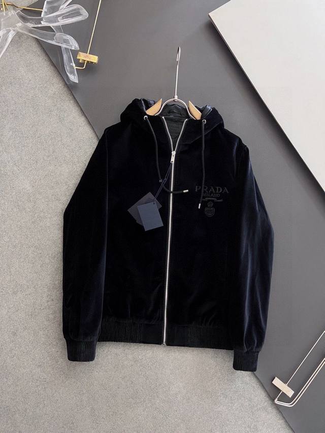 prad*丝绒连帽夹克外套，此款夹克外套选用了p家专业定制丝绒面料制成，表面整洁光滑且富有光泽，质感透过屏幕都显而易 见，上身舒适轻盈不闷热， 胸前精致Logo