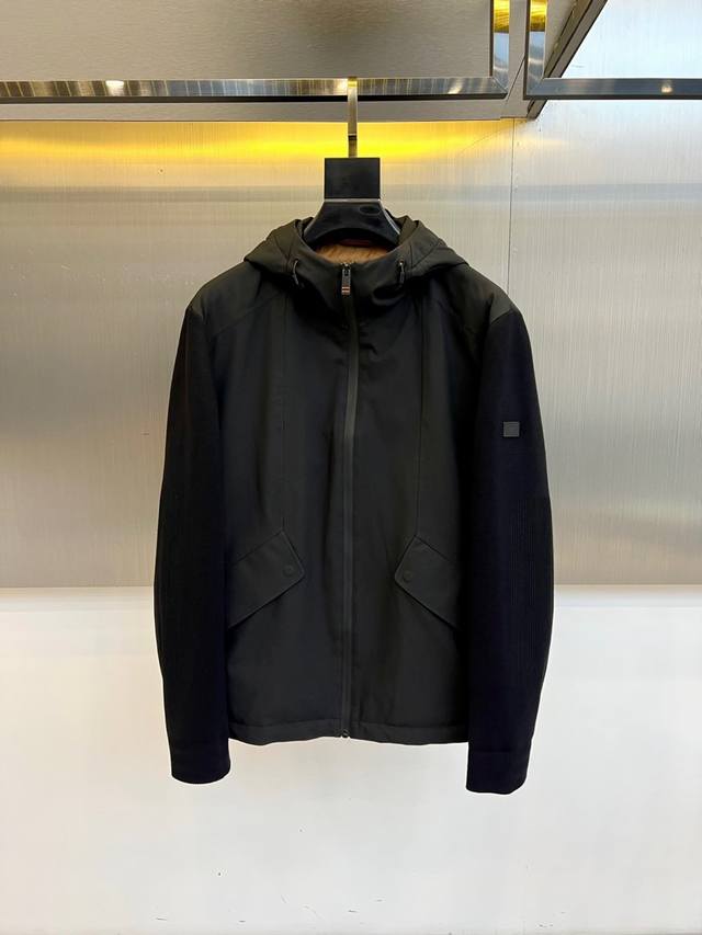 Zegna杰尼亚、2025秋冬新品黑色连帽夹克，以简约设计诠释现代机能美学。采用拉链开合设计，搭配金属质感抽绳扣连帽，兼顾防风实用性与造型感。胸前对称设计立体口