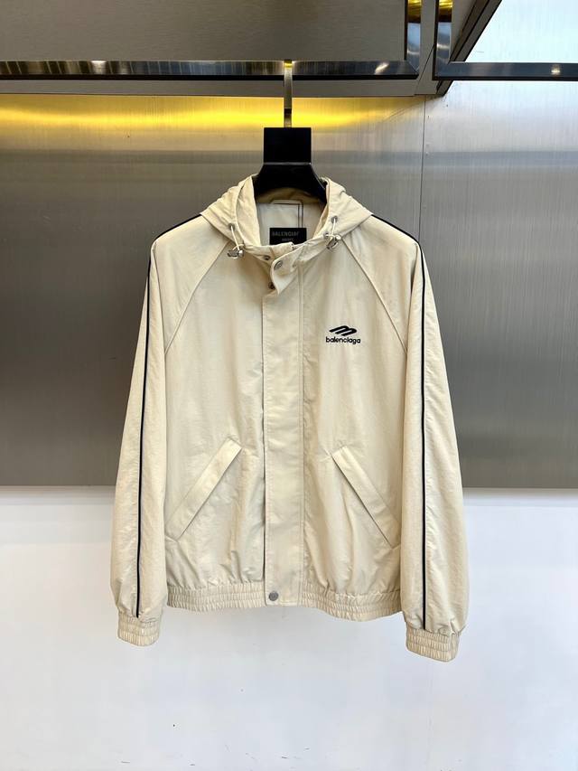 Balenciaga 巴黎世家、2025秋冬新品连帽夹克，以米白色调演绎解构主义美学。Oversize廓形搭配立体剪裁，衣袖拼接黑色条纹形成视觉延伸，左胸点缀品