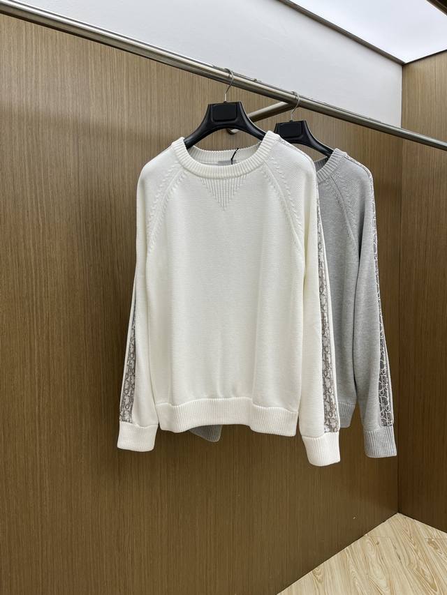 Dior迪奥秋冬经典男士针织长袖拼接圆领套头毛衣 这款针织衫向经典图案致敬。采用棉质平纹针织面料精心制作，衣袖饰以桑蚕丝 Oblique 印花条形细节，打造对比