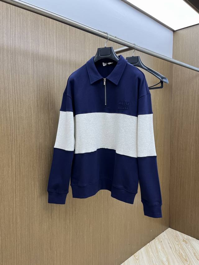 Miumiu缪缪2025秋冬半拉链卫衣，藏青与浅灰拼接超有设计感，半拉链立领增添利落与随性感。精致品牌标识点缀，细节处尽显轻奢格调，轻松打造出慵懒又时髦的造型，