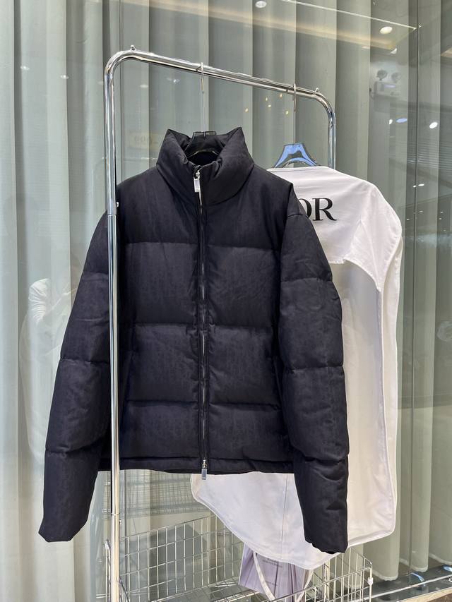 25年这款夹克突显 Dior 经典的 Oblique 印花。采用黑色科技提花面料精心制作，背面饰以 Dior 橡胶补丁，搭配立领彰显个性。通体饰以同色调印花，精