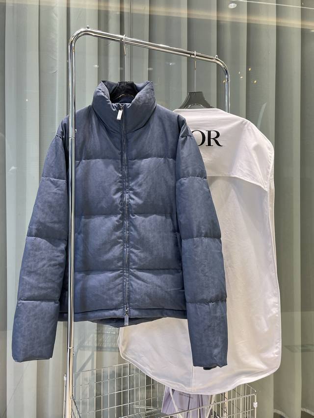 25年这款夹克突显 Dior 经典的 Oblique 印花。采用黑色科技提花面料精心制作，背面饰以 Dior 橡胶补丁，搭配立领彰显个性。通体饰以同色调印花，精