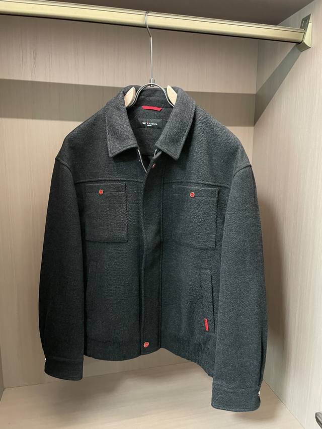 Kiton 2025秋冬新品夹克外套 经典的人字纹面料，自带细腻的纹理质感，黑色色调柔和又高级，在光影下流转着复古韵味；翻领设计利落有型，还原美式工装的硬朗风格