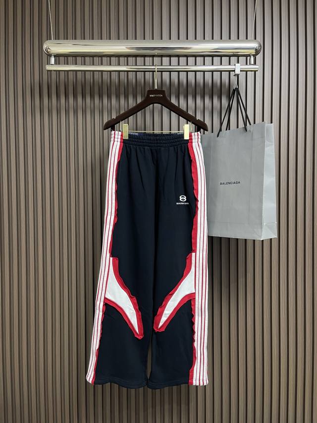 Balenciaga 拼色运动长裤，复古平纹针织面料，拼接间条16S+10S鱼鳞底卫衣面料，搭配同撞色平纹针织面料，制作出立体间条拼接设计，正面饰以艺术品绣花，