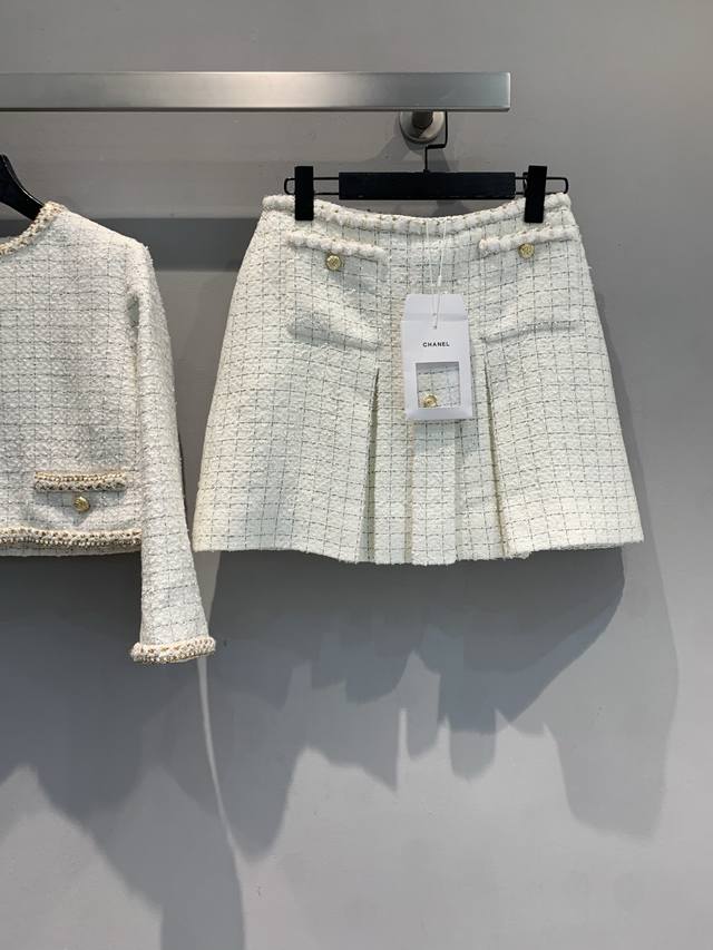 原版开发 C家2025早秋新款经典格纹金扣粗花呢半裙，格纹粗花呢面料质感满满，尽显大牌风范。腰间的纽扣设计，不仅增添了复古韵味，还能巧妙修饰腰线。裙身的褶裥处理