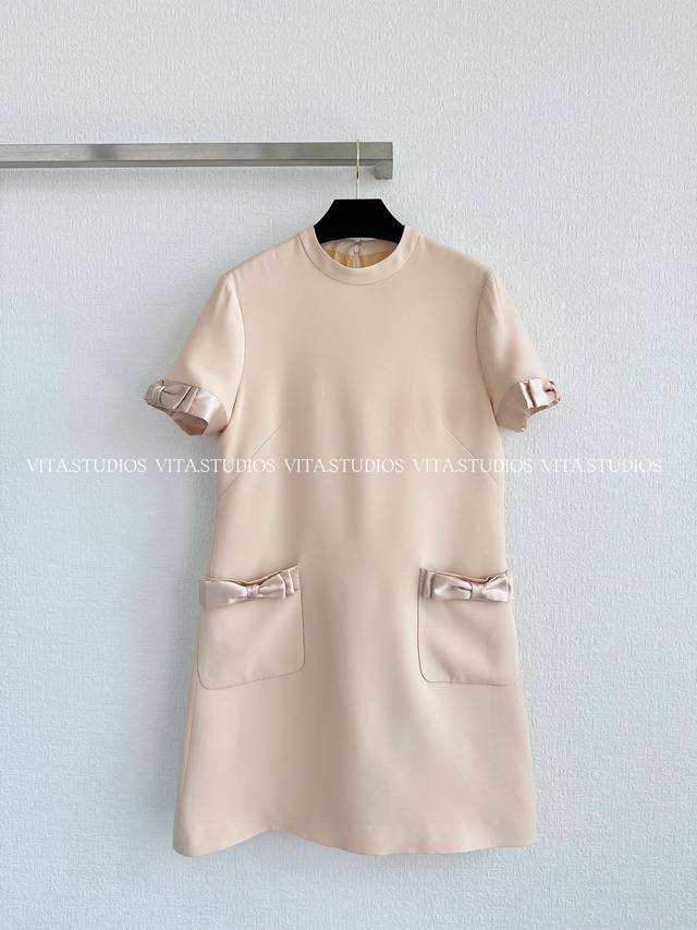 爆款现货 蝴蝶结连衣裙 选用定织定染丝毛材质，面布经染色后整件粘朴，赋予挺括质感；里布采用真丝，带来细腻亲肤的穿着体验。简约的短袖与圆领设计，袖口与袋口运用撞色