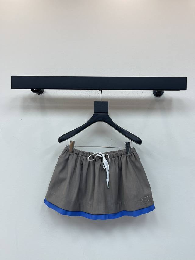 Miumi*25早秋新款华达呢迷你拼接半身裙。华达呢作为Miu标志性面料，重释这款迷你半身裙的廓形，搭配长春花府绸细节和运动风抽绳，增添现代实验风格。精湛工艺与
