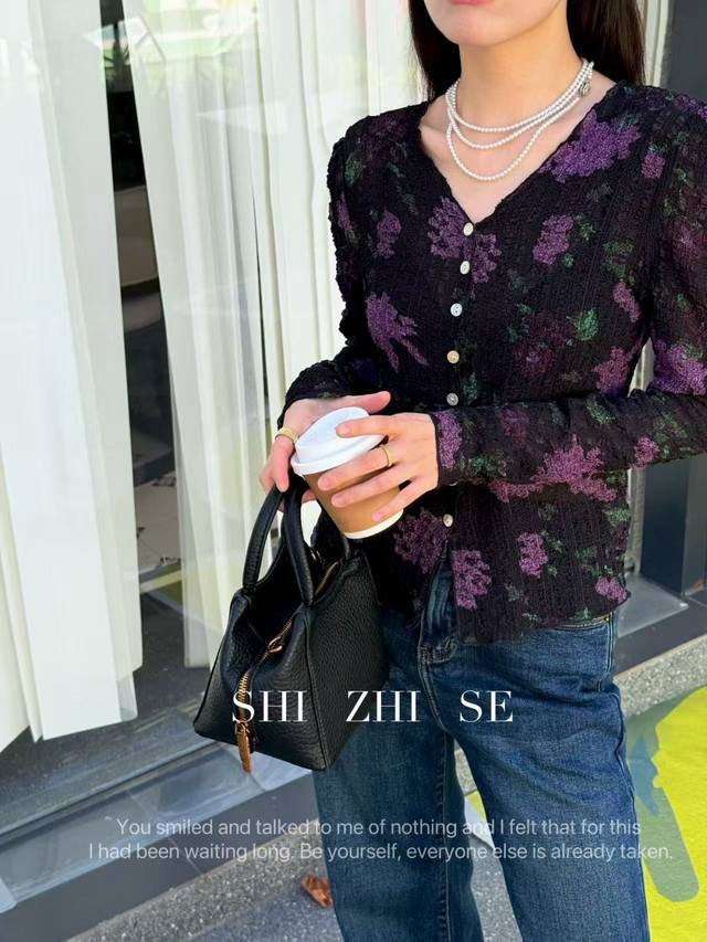 复古紫藤花拉皱小衫，深调底胚晕染紫花，莫奈花园的暮色漫溢，褶皱肌理如夜风拂过的涟漪，每道起伏都藏着法式慵懒的呼吸感 。领剪裁精准托出颈线 将复古与精致揉成克制的