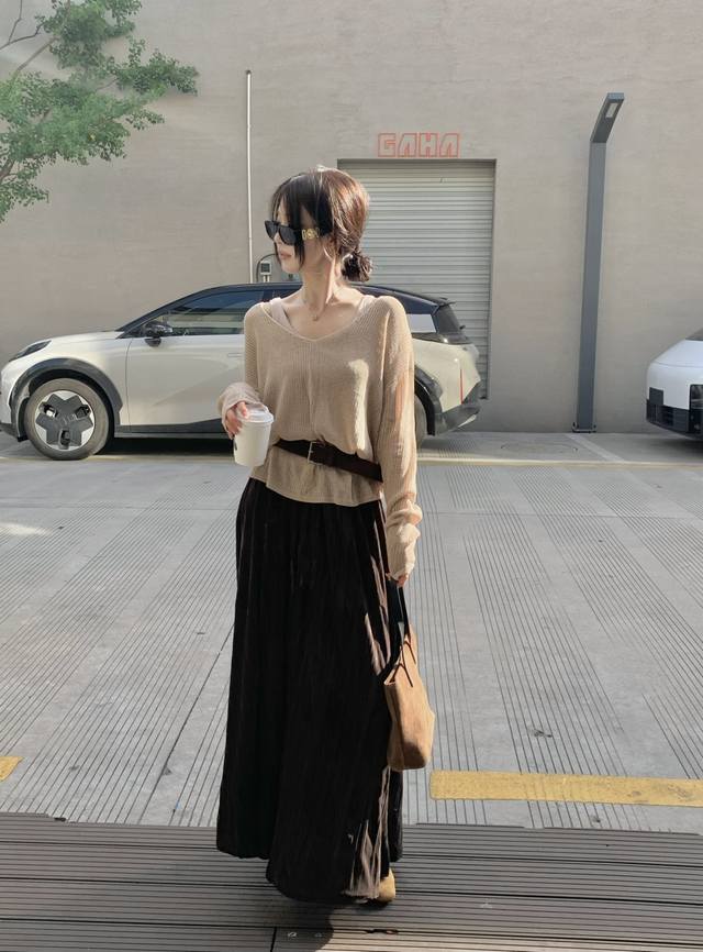镂空浅驼色针织上衣+背心+腰带+半裙套装 小众设计透着慵懒文艺，V领勾勒随性气质。搭配深棕半裙，垂坠感十足，走路带风超有范儿。加上一条皮带，随意一系，松弛与精致