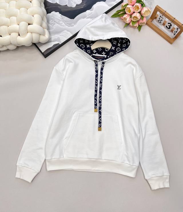Louis Vuitton Ski滑雪系列丝带花绳印花连帽卫衣，本款棉质连帽衫为风帽内部抽绳铺陈素雅 Monogram 印花，搭配耀目孔眼与考究抽绳端头，可轻松