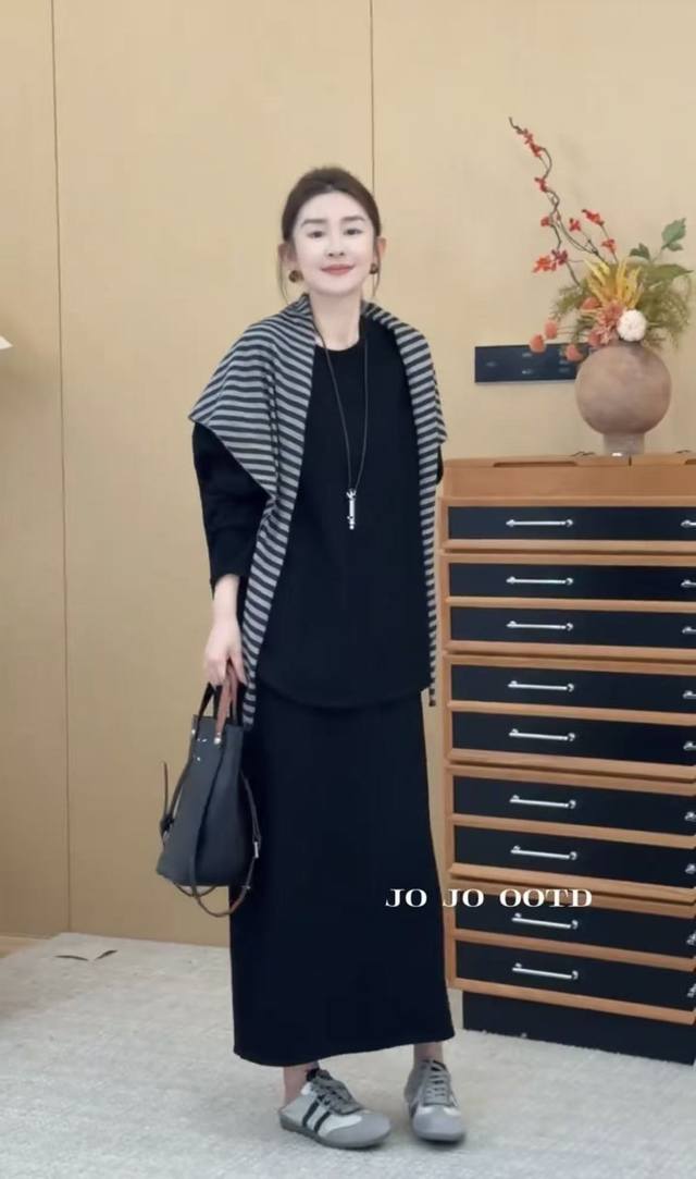 松弛慵懒感套装 宽松的上衣简约大气，恰到好处的落肩设计轻松营造出松弛感 搭配同色系长裙自然垂坠的裙摆走动间尽显优雅姿态 黑白条纹披肩随意搭在肩头彰显独特的个人风