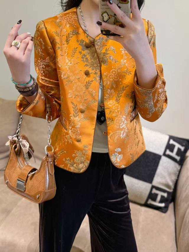 绿韵橙华 人丝提花外套暗橙作为打底色，呈现出一种沉静、端庄的美感，咖色的提花和翻袖则为其增添了一丝神秘的韵味。色彩沉稳、典雅，给人一种高贵而不失内敛的感觉。这种