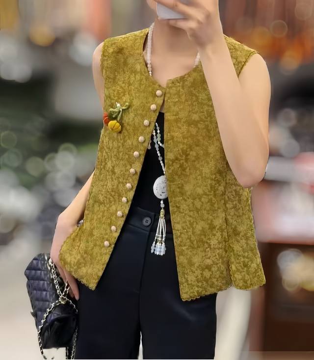 无敌爆款 中式复古排扣南瓜百搭马甲 采用带有精致纹理的面料，呈雅致的暖调色彩。无领设计搭配精致纽扣，侧边辅以花卉胸针点缀，细节处尽显匠心，整体散发着古典与时尚交