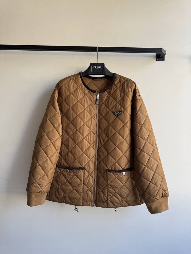 prad* 新款，菱格棉服外套，经典的圆领菱格纹棉服，一眼浓郁的焦糖色 复古又吸睛领口和口袋处都做了巧克力色灯芯绒包边，细腻又温暖～采用prada经典的再生尼龙