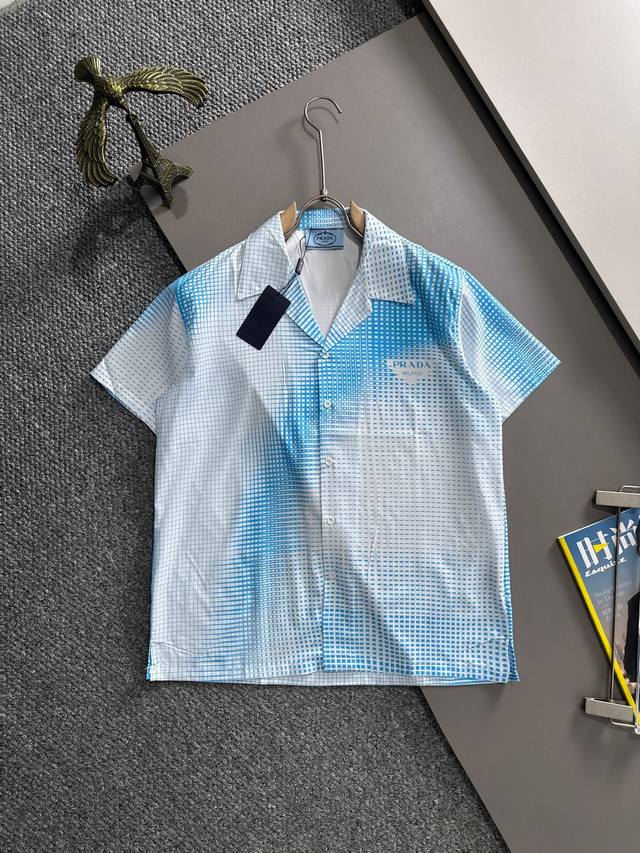 普拉达2025夏季经典Logo设计满印衬衫，轻薄棉质全身数码印花，采用优质聚酯纤维面料，精心打造标准版型，休闲时刻百搭款！经典Logo非常养眼醒目，彰显出高奢的