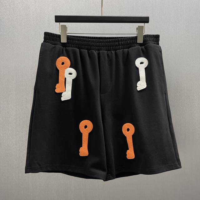 Lo*We 夜光钥匙刺绣短裤 Size : S-Xl 这是一款兼具时尚与趣味的短裤，主体为经典黑色，简约大方。上面绣有不同颜色的钥匙图案，普通光线下呈现橙、白等