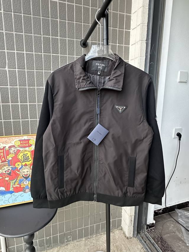 款号：Tt72 普拉达早春立领最新时尚春秋夹克外套。经典设计感与颜值爆棚的外套，品质更是无法挑剔品控可以直接入手，不容过错的高端臻品！通过细节图片便可感受到它强