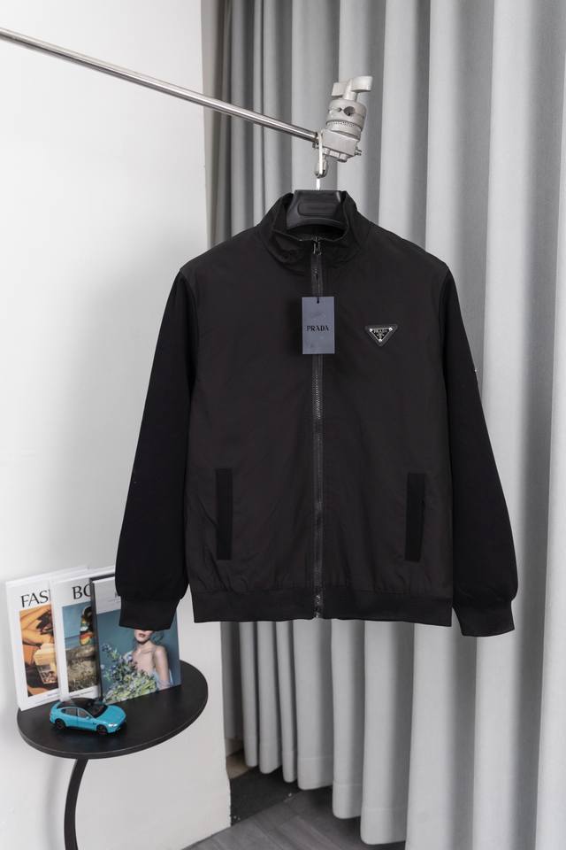 Su 款号：S004 普拉达早春立领最新时尚春秋夹克外套。经典设计感与颜值爆棚的外套，品质更是无法挑剔品控可以直接入手，不容过错的高端臻品！通过细节图片便可感受