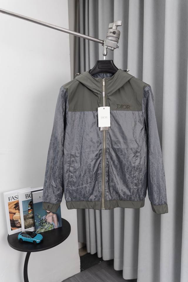 Su 款号M001 Dior 迪奥 胸前字母Logo满印拼接连帽外套 贸易渠道稀出，海外精品限量销售。户外风衣产品的典范，全身暗纹的商标彰显品牌辨识度。这款夹克