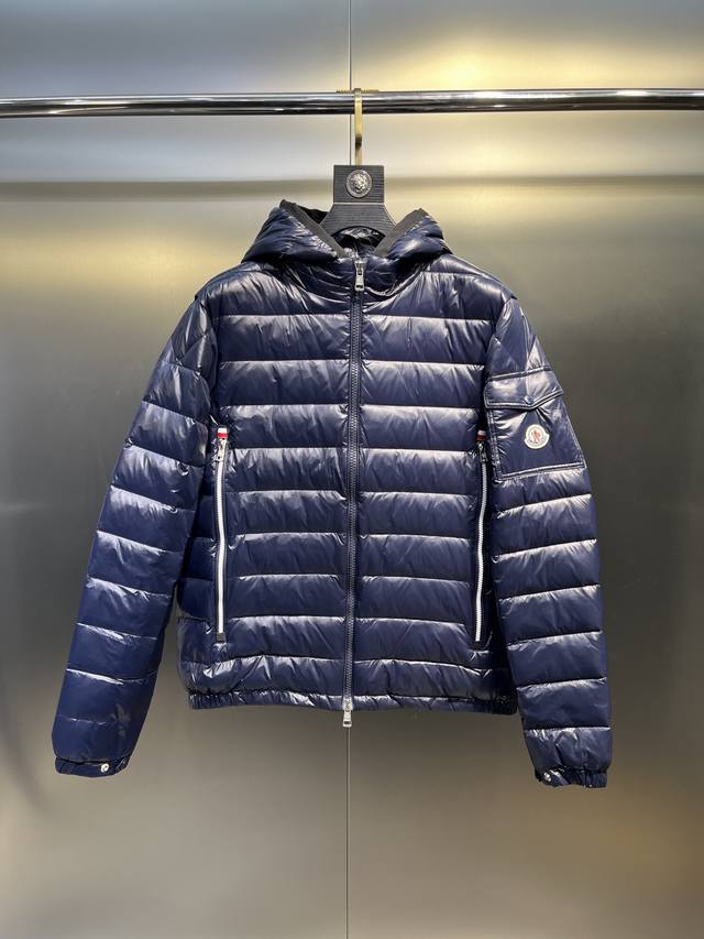 Moncler经典设计的代表作 Galion羽绒夹克采用标志性的Nylon Laqué面料制成。备有多种颜色可供选择，这款连帽羽绒服的直筒剪裁和方块格绗缝使其成