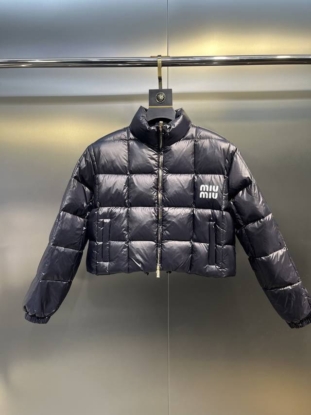 Miumiu女士徽标饰短裁尼龙短款羽绒服 这款尼龙羽绒外套演绎闲适、动感而别致的风格。柔软加衬衣身搭载弹力袖口和束绳下摆，平添休闲元素。印花徽标注入鲜明格调。