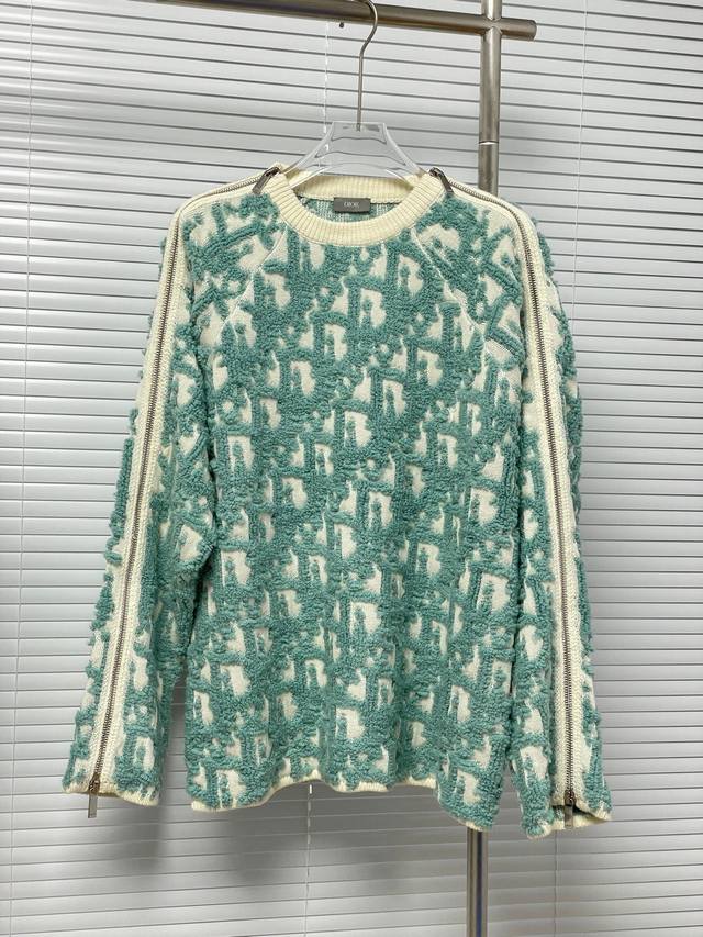 款号M27 Dior 羊毛混纺提花针织衫 这款针织衫采用白色绵羊毛混纺提花面料精心制作，通体饰以凸起的经典浅绿色 Oblique 印花图案提升格调。衣袖采用拉链