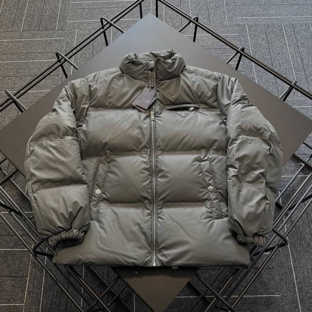 Prada 普拉达 科技皮膜羽绒夹克 压胶版本 此款衣服面料为25最新科技面料，保持了羊皮的柔软细腻质感，比起常规皮质羽绒服更佳轻便,易保养.充绒用的是国标90