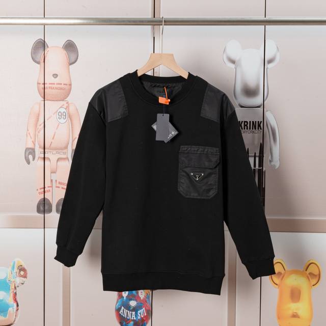 Prada普拉达圆领口袋三角标卫衣. 面料舒适柔软.复合奥粒绒，作工精细. 后幅做龟背.平纹布做搭色.还特原殊工带艺来的潮流，定制定染 ，三标齐全 非场市普通版