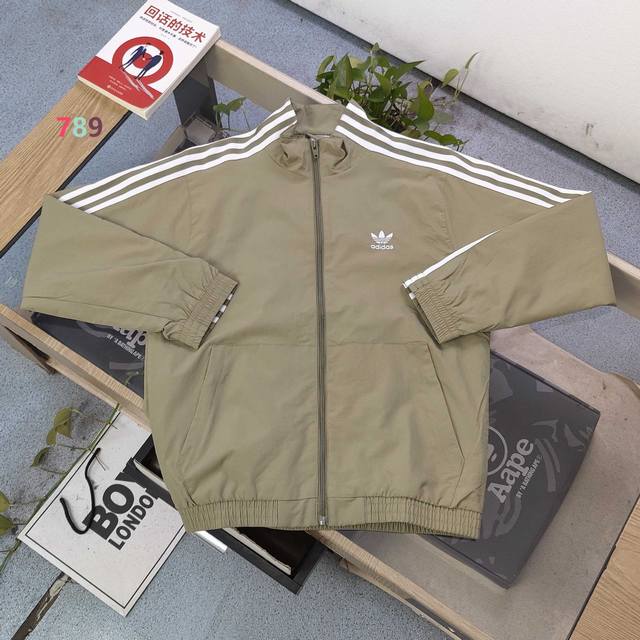 2025新款Adidas阿迪达斯刺绣三叶草三道杠绣花休闲情侣立领防风夹克外套，采用爽滑亲肤面料，面料厚实立体感更强，体感更舒服，定位裁剪，费时又废料，立体饱满，