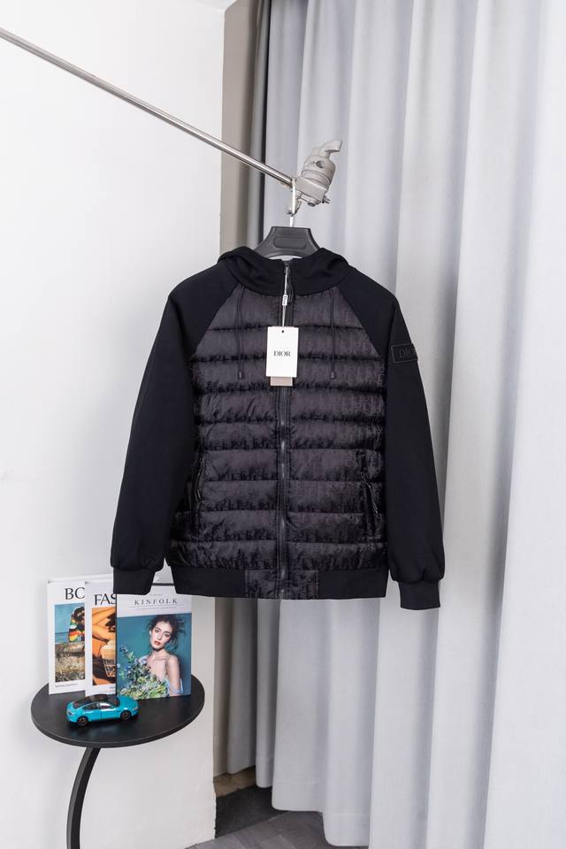 款号：S035 当巴黎时装屋的经典老花邂逅御寒刚需，这款 Dior 连帽棉服，以 “高级感拼接” 与 “标志性辨识度”，重新定义冬日奢装的打开方式。衣身满幅 D