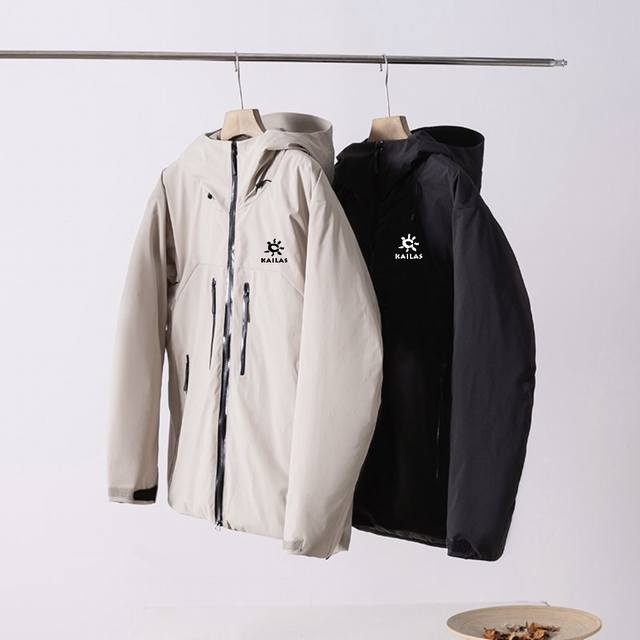 供 控 Kailas 凯乐石户外硬壳冲锋棉服，黑色、米白色两色可选！采用专业防水面料，防风防雨，全压胶工艺，腋下透气拉链设计。连帽拉链门襟，两侧拉链口袋，袖口魔