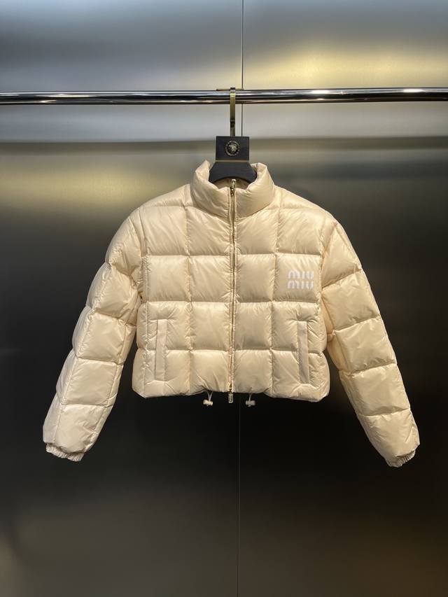 Miumiu女士徽标饰短裁尼龙短款羽绒服 这款尼龙羽绒外套演绎闲适、动感而别致的风格。柔软加衬衣身搭载弹力袖口和束绳下摆，平添休闲元素。印花徽标注入鲜明格调。