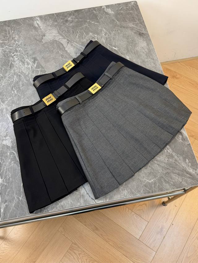 25新款腰间配有黑色皮质腰带 为整体造型增添了一丝酷感 醒目的黄色腰牌上印有“Miu Miu”的品牌标识不仅彰显了品牌身份 还为简约的裙子增添了亮眼的细节 无论