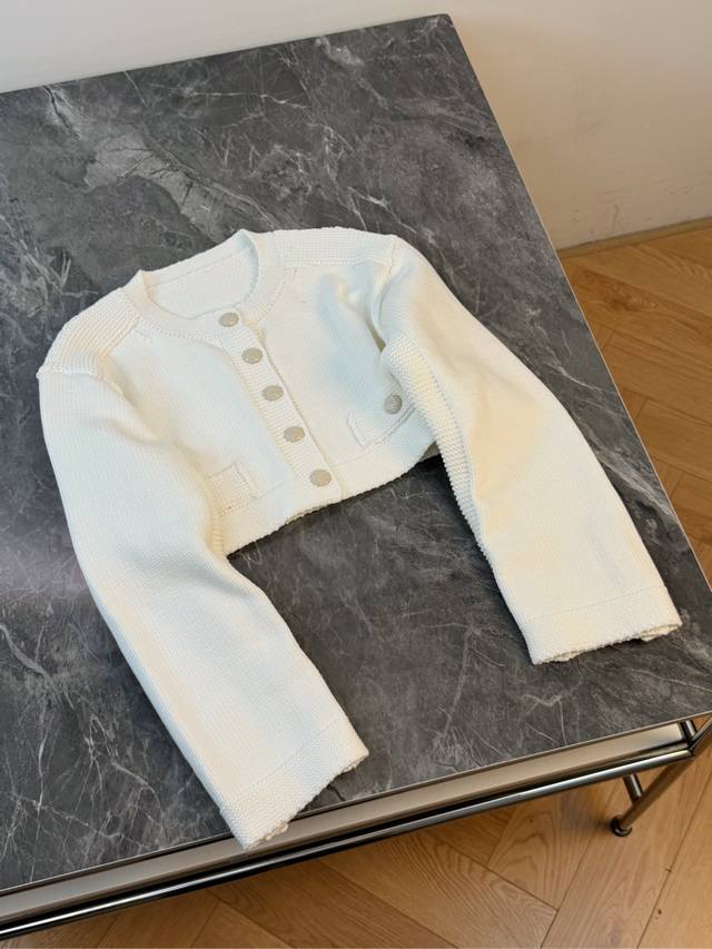 25新款 白色短款针织外套 太精致啦～柔和的白色 干净又显气质 经典的圆领设计 搭配一排金属质感的纽扣 简约中透着优雅 短款的版型 能够很好地优化身材比例 露出