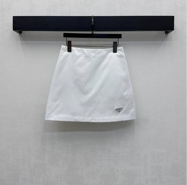 Prad*2025新品上架 高腰夹棉半裙 定制Yb进口防风防水尼龙材质 内里衔棉填充 整件轻盈保暖 裙摆点缀标志性三角徽标装饰 彰显品牌调性 侧边拉链调节设计方