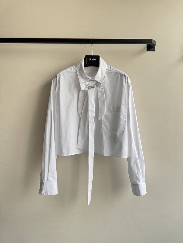 Prad* 25秋冬新款 短款蝴蝶结衬衫 后背有经典品牌倒三角标识,衬衣真的是衣柜必不可少的单品！宽松版型完全不挑身材 慵懒又随意的感觉真的太好穿了！时髦精们B