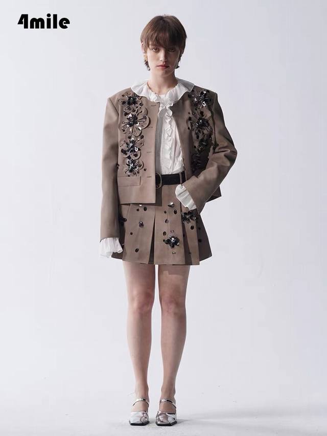 套装 秋冬卡其色钉珠亮片套装，包含圆领短款外套与A字短裙。外套与裙身均饰有立体花朵钉珠+亮片装饰，点缀黑钻般细节，精致吸睛；外套设金属纽扣与假口袋，版型利落；短