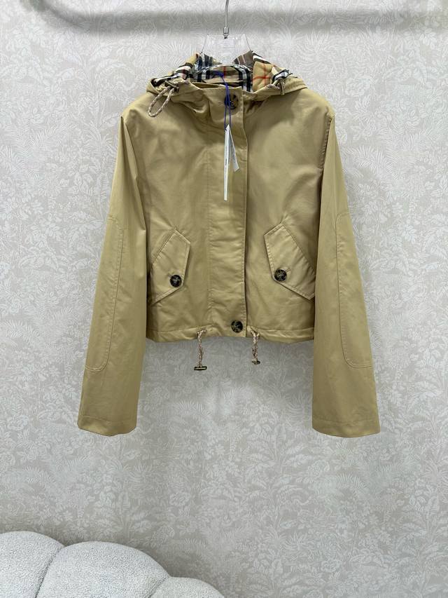 Burberr* 25早秋新款 苏格兰格纹短款连帽外套丨独家高版出品！以柔和卡其色为主色调，兼具休闲与精致感。采用哑光质感面料打造，连帽内侧衬以品牌标志性格纹，