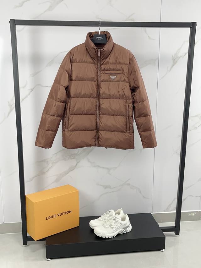 新款上架 Prada 普拉达 25秋冬新款羽绒服外套，立领金典款式轻便蓬松保暖舒适，经典百搭实穿，保真品质，羽绒作为衣橱必备的单品，混搭系数极高，极具时髦感且充