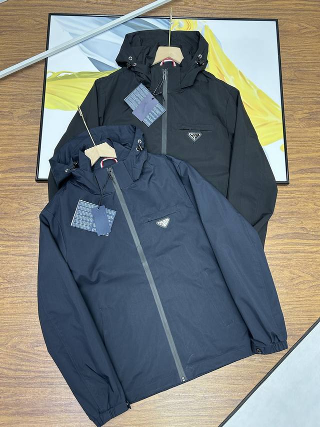 早秋新款Prada 普拉达男士25早春秀场新款 男士轻奢商务休闲连帽夹克外套。客供的复合科技面料表层防水中间层锁温底层快速排汗。三层复合功能性更加强大满足穿着者
