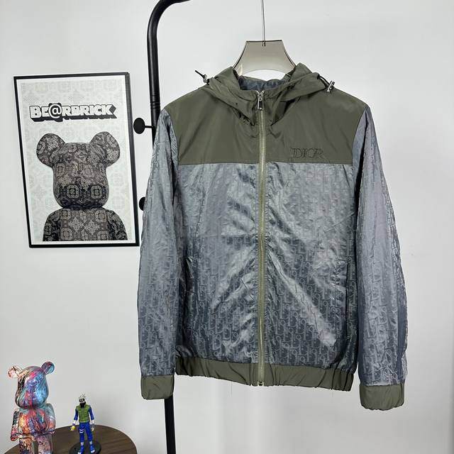 款号:Z09 Dior 迪奥 胸前字母Logo满印拼接连帽外套 贸易渠道稀出，海外精品限量销售。户外风衣产品的典范，全身暗纹的商标彰显品牌辨识度。这款夹克兼备温
