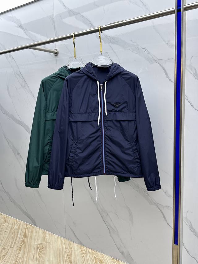 Prad*普拉达 25Ss新款受科技服饰启发的短夹克具有轻盈、运动的设计，并以精致的风格重新诠释了功能性细节。该服装采用再生尼龙制成，这是一种象征性的Prada