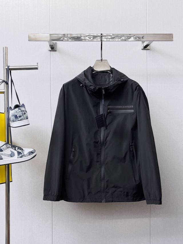 普拉达 2025春秋新品时尚休闲连帽夹克外套，进口原版科技面料，上身舒适透气，胸前精致手工工艺Logo，独特设计欧洲时尚风格，反面数码定位印花工艺，彰显了年轻人