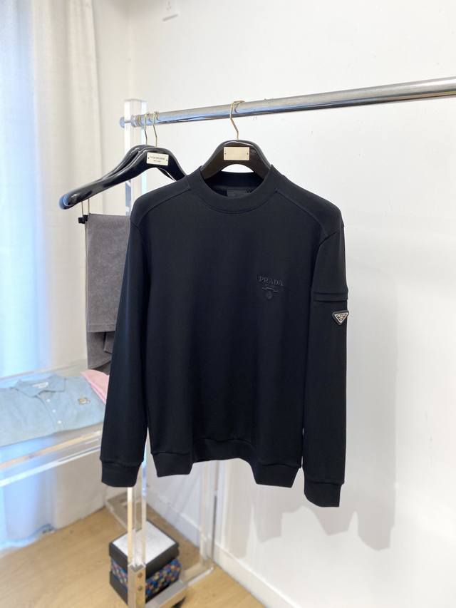 普拉达、2025新品长袖卫衣，帅气时尚，袖口五金装饰三角标Logo，简约百搭款。面料棉 不仅挺括，保持潮流的廓形，又穿着舒适，纱织更细腻，码数M-3Xl